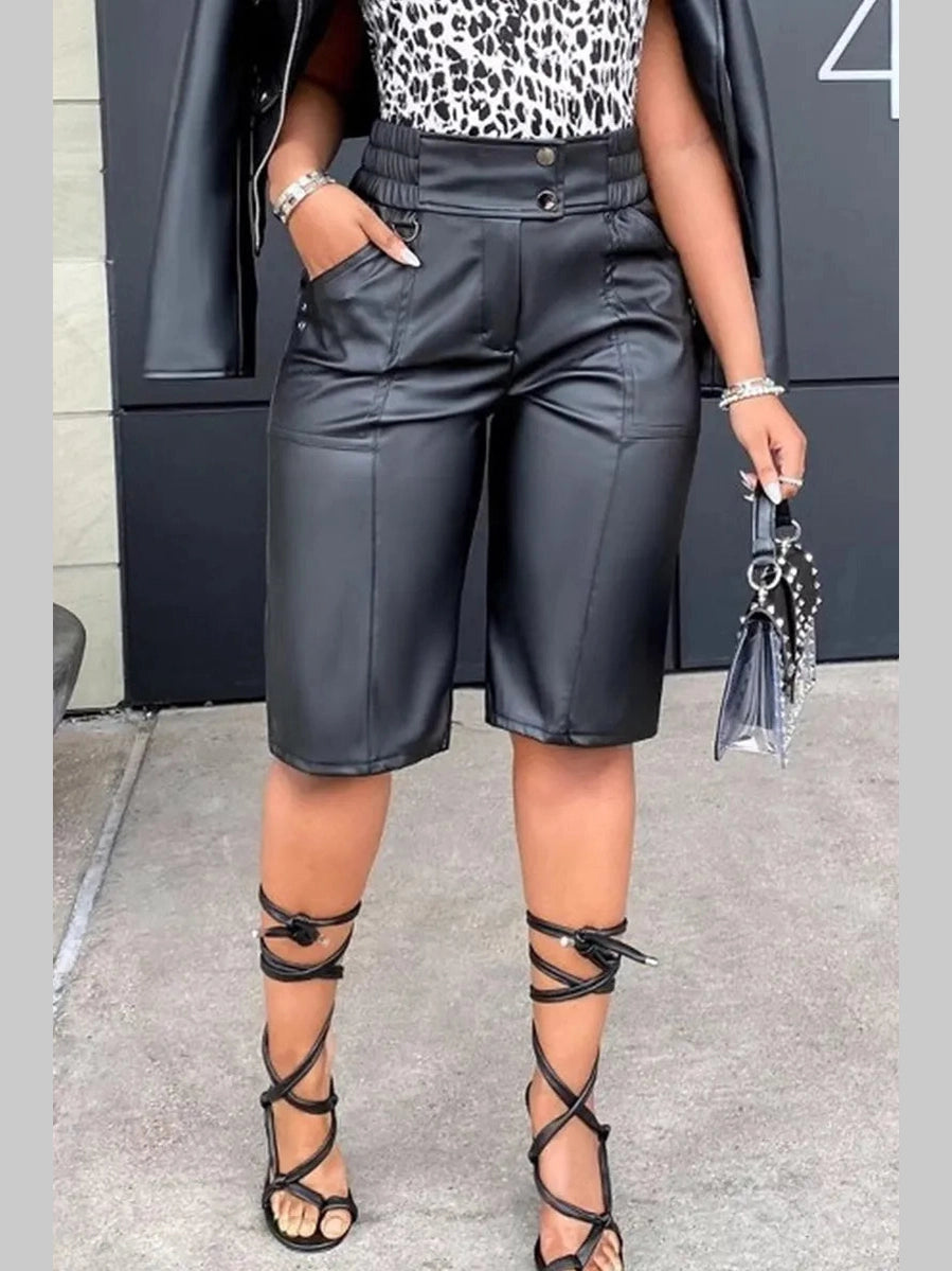 Close-up of the faux leather texture and zipper closure on black longline shorts.